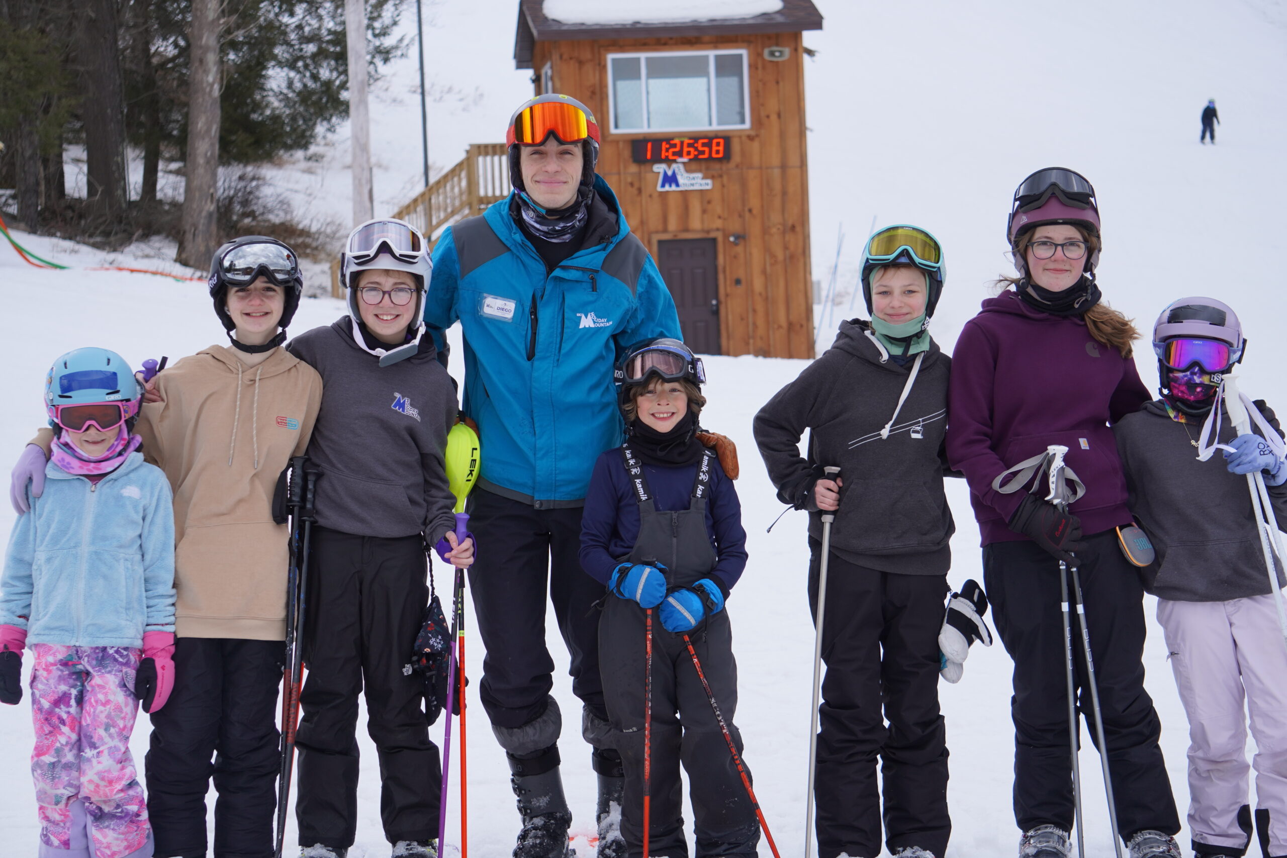 Ski instructor with a group of kids posing for a picture