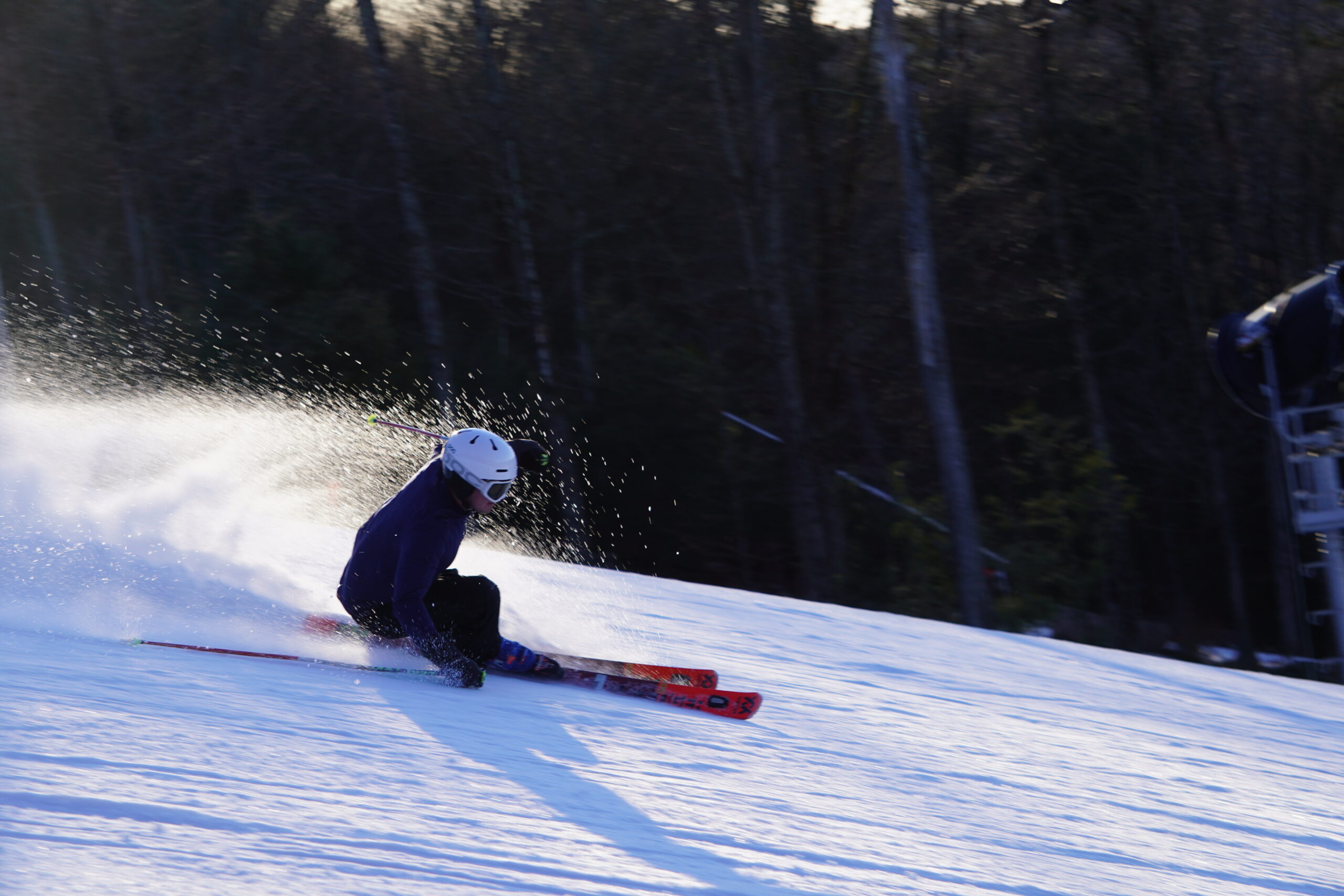 Skier with snow spraying during sunset
